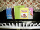 保育士のピアノ教本数冊とピアノの写真